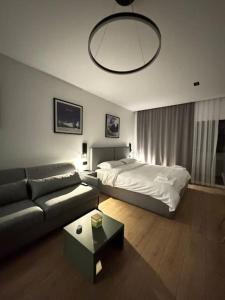 a living room with a bed and a couch at Boutique Flat in the City Center in Tirana