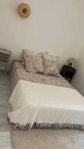 a white bedroom with a bed with a white blanket at Maison de village Azillanet in Azillanet