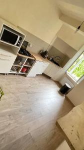 a kitchen with white cabinets and a wooden floor at Maison de village Azillanet in Azillanet