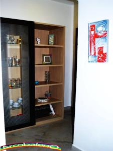 Zimmer mit Bücherregal und Mikrowelle in der Unterkunft Il Nuovo Arcobaleno in Alghero