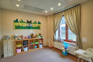 a childs room with toys on shelves and a window at Hotel Toč in Lipova Lazne