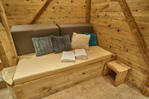 a bench in a wooden cabin with pillows on it at Hotel Toč in Lipova Lazne