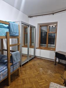 a room with a bunk bed and two windows at Buddha Hostel in Chişinău