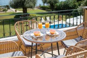 a table with two glasses of orange juice on a balcony at Cote Jardin in Barbati