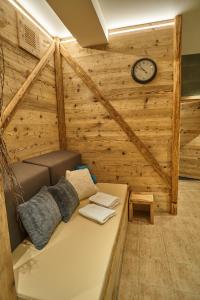 a room with a couch and a clock on the wall at Hotel Toč in Lipova Lazne