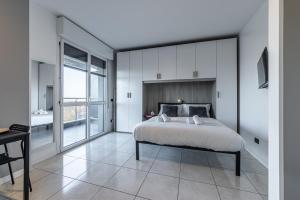 a bedroom with a large bed and a balcony at Cosenz Charme Apartment in Milan