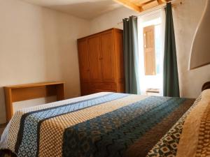 1 dormitorio con 1 cama, vestidor y ventana en Casas cuevas, Los Cabucos, en Agaete