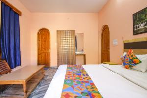 FabExpress Malti Guest House في كولو: غرفة نوم بسرير وطاولة خشبية