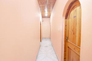 a narrow hallway with a wooden door and a mattress at FabExpress Malti Guest House in Kulu