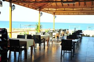 un restaurante con mesas y sillas y la playa en Önder Yıldız Hotel, en Kızılot