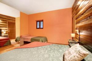1 dormitorio con 2 camas y paredes de color naranja en Aguamansa Relax, en La Orotava