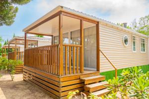 a tiny house with a screened in porch at Camping Relax Sol in Torredembarra