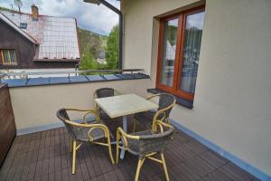 a table and chairs sitting on a balcony at Hotel Toč in Lipova Lazne