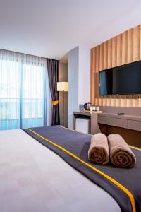 a hotel room with a large bed with a flat screen tv at Saint Star Kemer - Adult Only in Kemer