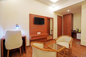 uma sala de estar com uma mesa e cadeiras e uma televisão em Diamond Admire Hotel & Banquets by MMD em Noida