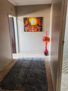 a room with a vase with a painting on the wall at Mimosa's @ 44 in Roodepoort