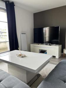 uma sala de estar com uma mesa branca e uma televisão em Big duplex 15 min from Paris city center - Metro station Line 5 em Bobigny