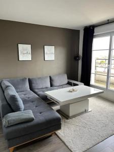 uma sala de estar com um sofá e uma mesa de centro em Big duplex 15 min from Paris city center - Metro station Line 5 em Bobigny