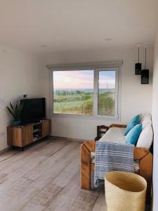 a living room with a couch and a television at La Casa de Caro Playa in Mar de Cobo