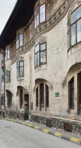 um antigo edifício de pedra com janelas numa rua em Fadilpasic's House em Sarajevo