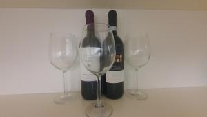 three wine glasses and a bottle of wine at MERCADANTE - Luxury Holiday House in Cassano delle Murge