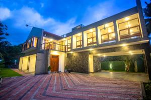a large house with a driveway at night at Villa Senaya in Galle
