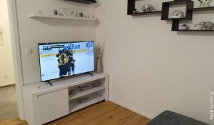 a living room with a tv in a white cabinet at APARTMÁN KRISTÝNA in Svoboda nad Úpou