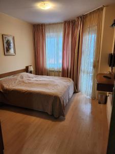 sypialnia z łóżkiem i dużym oknem w obiekcie Royal Plaza Apartments Borovets w Borowcu