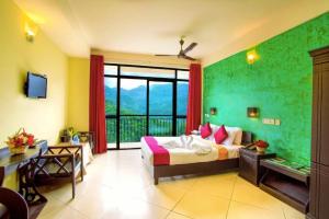- une chambre avec un lit et une grande fenêtre dans l'établissement The View Munnar, à Anachal