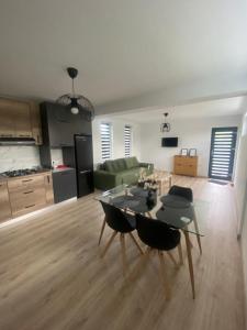 皮特什蒂TTT House Pitesti的一间厨房和一间带桌椅的客厅