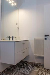 a white bathroom with a sink and a mirror at Old Town Premium Apartment by MRG in Bucharest