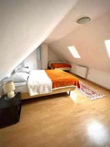 a attic bedroom with a bed with an orange blanket at La Mama in Pietroasa