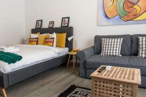 a living room with a bed and a couch at Old Town Premium Apartment by MRG in Bucharest