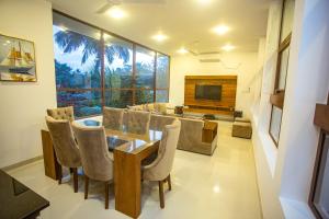 a dining room with a table and chairs and a television at Villa Senaya in Galle