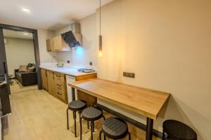 a kitchen with a wooden table and stools at LELİKO SUITES in Antalya