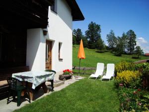 patio ze stołem, krzesłami i pomarańczowym parasolem w obiekcie Schoner Erika w mieście Oberau +6 zdjęć