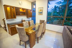 a dining room with a glass table and chairs at Villa Senaya in Galle