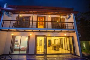 a house at night with a balcony on it at Villa Senaya in Galle