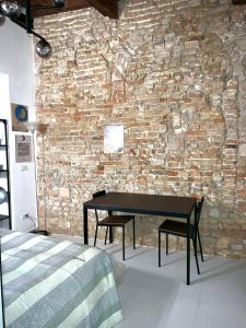 ein Schlafzimmer mit einem Tisch und einer Backsteinwand in der Unterkunft Da Carlin in Cesena