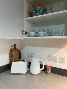 a kitchen counter with a toaster and a tea kettle at Urban 2 Bedroom with Parking in West Bromwich