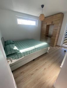 sypialnia z łóżkiem z zieloną pościelą i oknem w obiekcie TTT House Pitesti w Piteszti