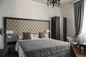 a bedroom with a large bed with a large headboard at Hotel Re Enzo in Bologna