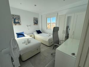 a white room with two beds and a desk at Nina's crib 2BR flat in Boliches in Fuengirola