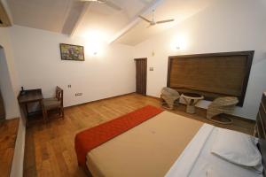 a bedroom with a bed and a desk and a table at Wild Woods Tiger Resort in Nagpur
