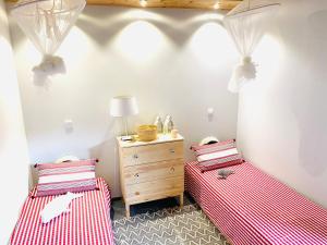 2 camas en una habitación con sábanas rojas y blancas en WAKA PICO AZORES, en São Roque do Pico
