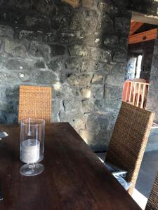 een houten tafel met een glas water erop bij WAKA PICO AZORES in São Roque do Pico