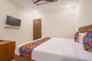 a bedroom with a bed and a flat screen tv at FabHotel Air Live in Hyderabad