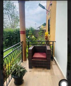 a porch with a wicker chair on a balcony at Katabi Green Escape in Entebbe
