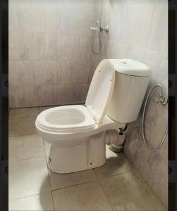 a white toilet in a bathroom with a shower at Katabi Green Escape in Entebbe +9 photos