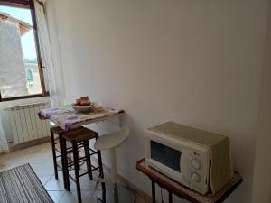 a small kitchen with a table and a microwave at I tetti di Pavia in Pavia